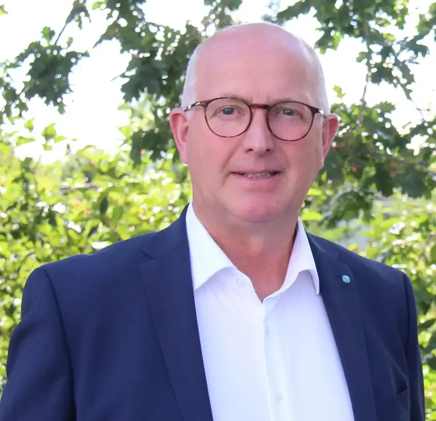 Mand med briller iført blå jakke og hvid skjorte