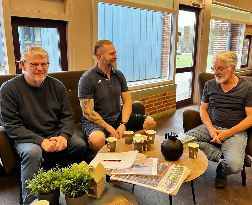 Tre mænd som drikker kaffe