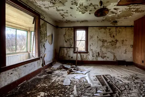 Stuen i et forladt hus. Ødelagte gulv og manglende vinduer