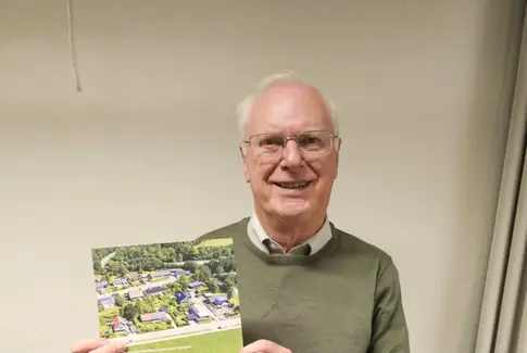 Mand i grøn trøje holder en bog