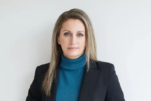 Smuk kvinde i blå trøje og mørk jakke