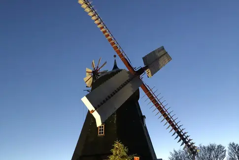 Gammel mølle med fire vinger mod blå aftenhimmel